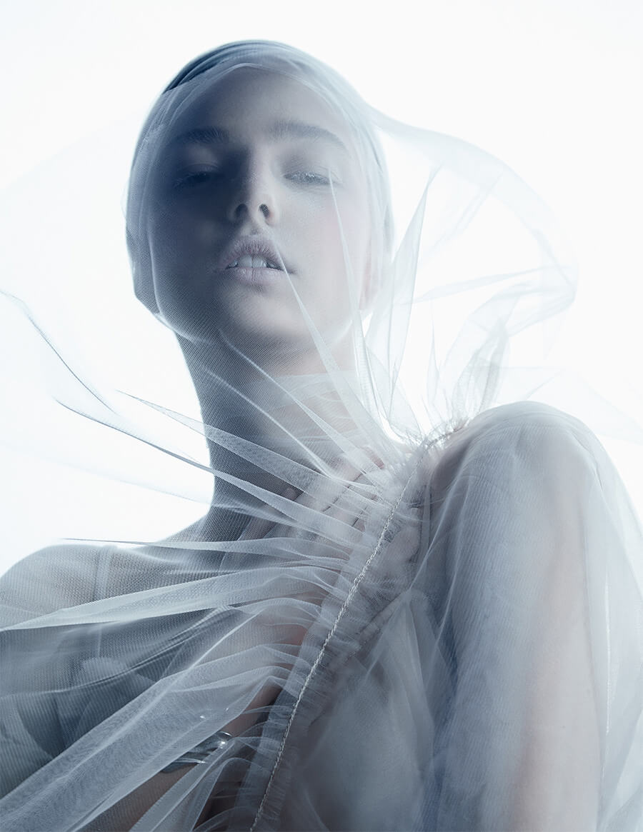 Person wrapped in translucent white fabric.